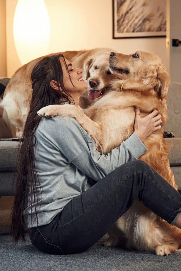 Woman cuddling 2 goldens during live-in pet care visit Live-In Pet Care (24-Hour) in Titusville, Mims & Northern Brevard County, FL​